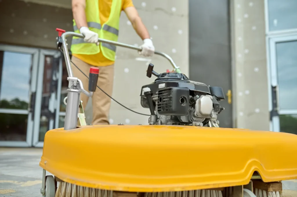 workman applying road sweeper construction site, Post-Construction Cleaning in Miami